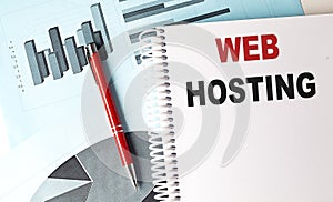 WEB HOSTING text on a notebook with pen on a chart background