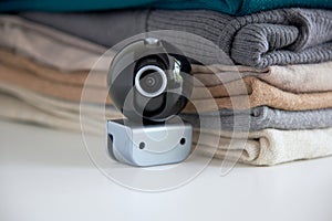 Webcam hidden in a stack of clothes for covert surveillance of the house.