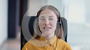 Webcam pov portrait of young professional woman helpline operator wearing headset with mic talking to camera at office