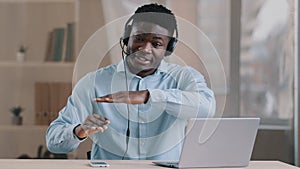 Webcam view young smiling male operator african american man teacher support service assistant wear headset talk at