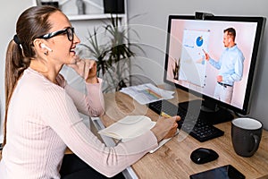 A woman in office is watching online classes photo