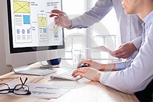 Website development team sketching wireframe layout for responsive web content