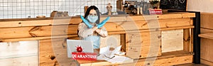 Website header of cafe owner in medical mask showing no sign at table with laptop, papers