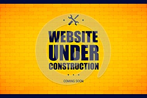 Website under construction sign on a brick wall.