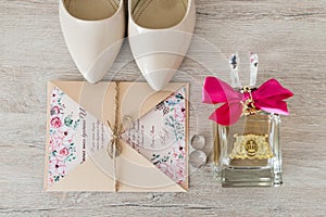 Wedding accessories: bridal shoes, rings, invitation, perfume. Wedding details in beige shades.