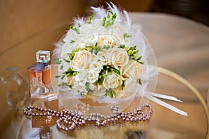 Wedding accessories. The bride's bouquet, pearls, perfumes and w