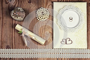 Wedding accessories and invitations to frame light wooden table