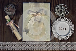 Wedding accessories and invitations to frame light wooden table