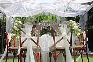 wedding altar and row of brown chairs shot at low angle prepared on the beautiful park or garden