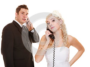 Wedding. Angry bride and groom talking on phone