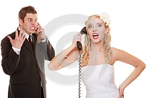 Wedding. Angry bride and groom talking on phone