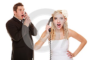 Wedding. Angry bride and groom talking on phone