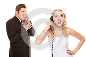 Wedding. Angry bride and groom talking on phone