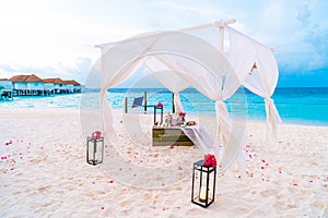 wedding arch on beach with tropical Maldives resort and sea