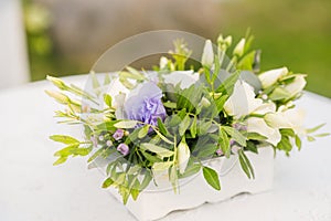 The wedding arch is decorated with blue flowers and white light silk. Summer ceremony. Bridal bouquet