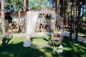 Wedding arch decorated with flowers in the forest