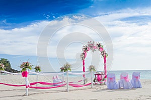 Wedding arch decorated with flowers on tropical beach, outd