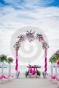 Wedding arch decorated with flowers on tropical beach, outd