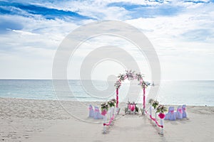 Wedding arch decorated with flowers on tropical beach, outd