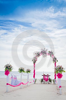 Wedding arch decorated with flowers on tropical beach, outd