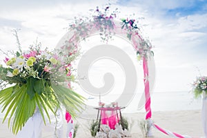 Wedding arch decorated with flowers on tropical beach, outd