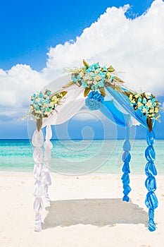 Wedding arch decorated with flowers on tropical beach, outd