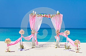 Wedding arch decorated with flowers on tropical beach, outd