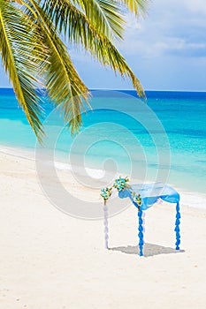 Wedding arch decorated with flowers on tropical beach, outd