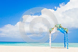 Wedding arch decorated with flowers on tropical beach, outd