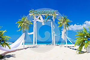 Wedding arch decorated with flowers on tropical beach, outd