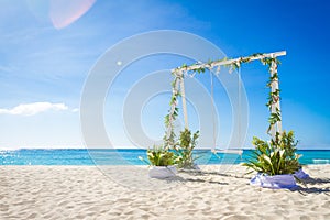 Wedding arch decorated with flowers on tropical beach, outd