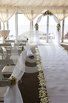 Wedding arch decorated with flowers. White carpet in the restaurant