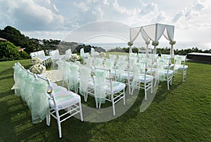 Wedding arch decorated with white and green flowers outdoors. Be