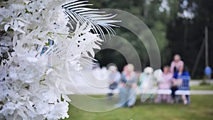 Wedding arch flowers in the background of the guests waiting for the wedding registration in nature.