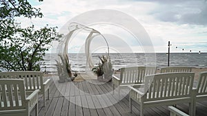 Wedding Arch with Flowers and Chairs. Ceremony venue outdoors.