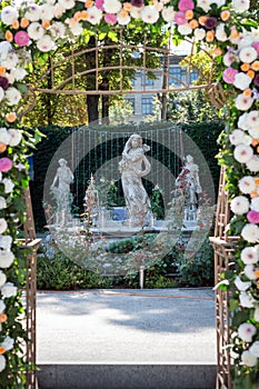 Wedding arch with flowers outdoors. Beautiful wedding set up. Wedding ceremony in the garden with sculptures and