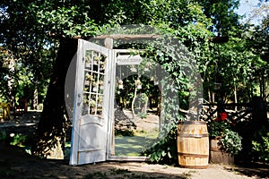 Wedding arch with white door overgrown with ivy