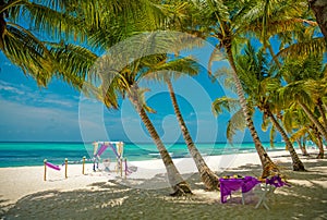 Wedding archway are arranged on the sand in preparation for a beach wedding ceremony.