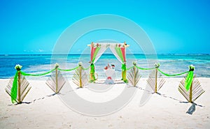 Wedding archway are arranged on the sand in preparation for a beach wedding ceremony.