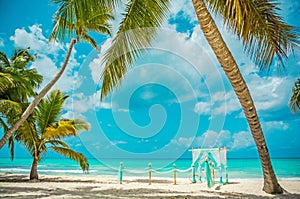 Wedding archway are arranged on the sand in preparation for a beach wedding ceremony.