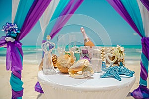 Wedding archway are arranged on the sand in preparation for a beach wedding ceremony.