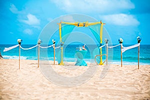 Wedding archway are arranged on the sand in preparation for a beach wedding ceremony.