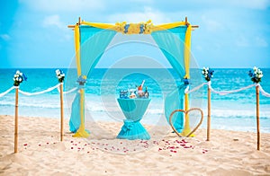 Wedding archway are arranged on the sand in preparation for a beach wedding ceremony.