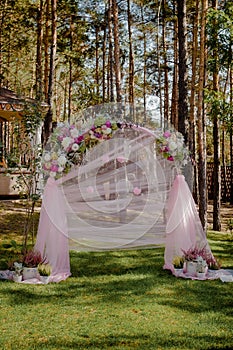 Wedding archway with flowers arranged in park for a wedding ceremony