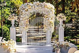 Wedding archway with flowers arranged in park for a wedding ceremony. Tender arch for celebration.