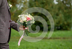 Wedding background, bouquet in the hands of the groom