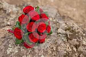 Wedding background bouquet and rings. The bride`s bouquet of red roses on the stone. love