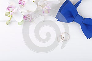 Wedding background with golden rings on white wooden table