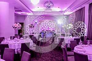 Wedding banquet in blue and white tones. Beautiful table setting with crockery and white flower arrangements in a vase on a high