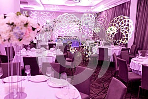 Wedding banquet in blue and white tones. Beautiful table setting with crockery and white flower arrangements in a vase on a high